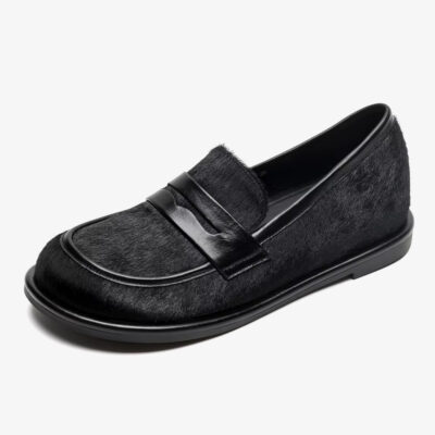 Un mocassino nero in pelle e crine di cavallo su sfondo bianco